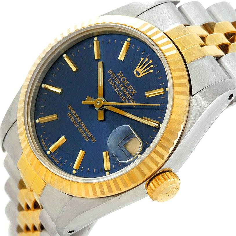 The Rolex Mid-Size 68273 Women's Stainless Steel Blue Dial 68273 Women's Stainless Steel Blue Dial watch is shown at an angled close-up, highlighting its blue dial, gold fluted bezel, and two-tone bracelet.