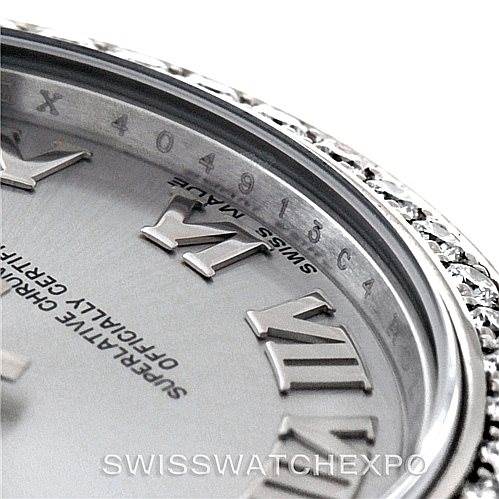 A close-up of the Rolex Mid-Size 178384 Women's Stainless Steel Grey Dial 178384 Women's Stainless Steel Grey Dial watch face focuses on the Roman numerals and part of the bezel.