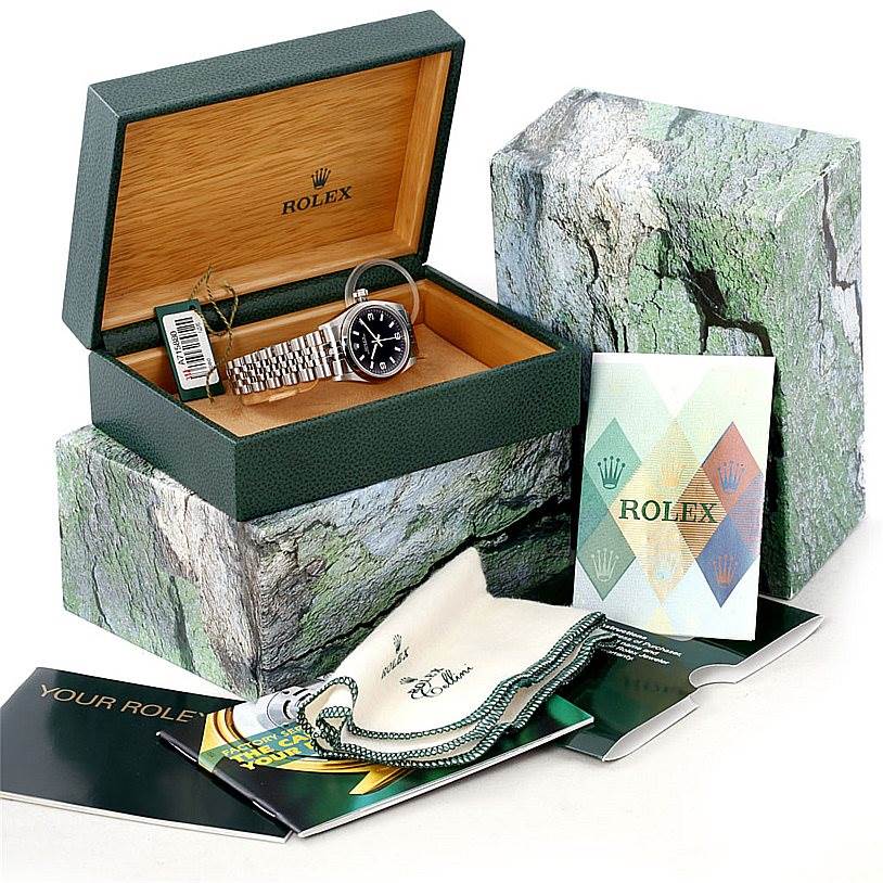 This image shows a Rolex Mid-Size 77080 Women's Stainless Steel Black Dial 77080 Women's Stainless Steel Black Dial model watch inside an open box with its accessories, including manuals, tag, and cloth.