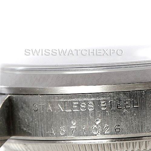 The image shows a close-up of the side and case back of a mid-size Rolex watch, highlighting the "stainless steel" engraving and serial number.