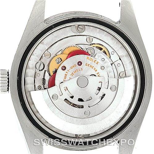 The image shows the open back view of a Mid-Size Rolex watch, focusing on its intricate movement and components.