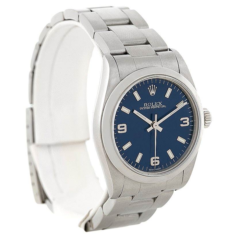 The Rolex Mid-Size 77080 Women's Stainless Steel Blue Dial 77080 Women's Stainless Steel Blue Dial model is shown at a three-quarter angle, displaying its face, crown, and part of its bracelet.