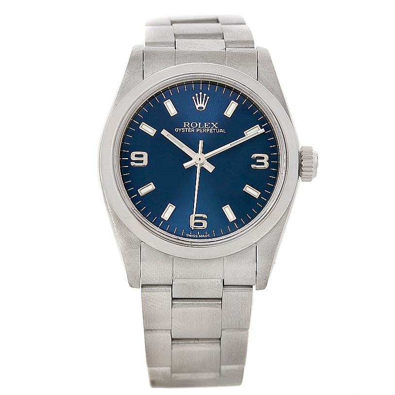 The image shows a front view of a Mid-Size Rolex Oyster Perpetual watch with its blue dial and stainless steel bracelet.