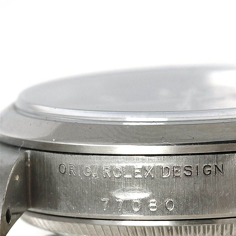 This close-up image shows the side case and bezel of a Mid-Size Rolex watch, with the engraved text "ORIG ROLEX DESIGN 77080".
