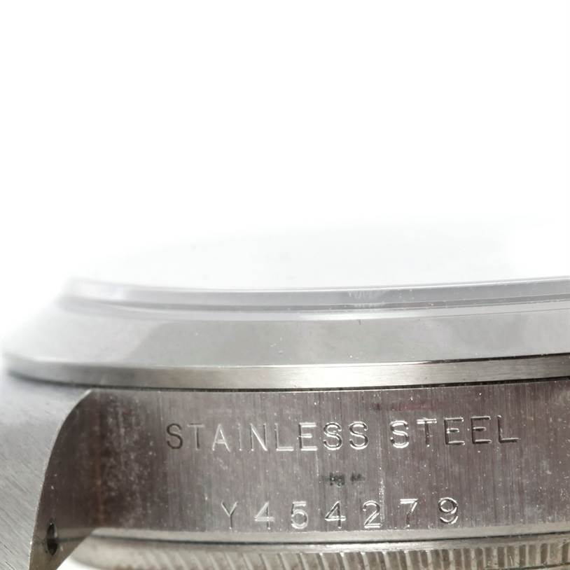 This image shows a side view of a stainless steel case with engraved details on a Mid-Size Rolex watch.