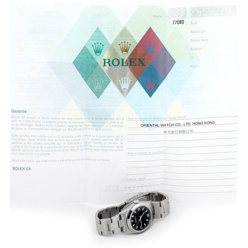 The image shows a Rolex Mid-Size 77080 Women's Stainless Steel Black Dial 77080 Women's Stainless Steel Black Dial model watch laying flat with its certificate of authenticity displayed behind it.
