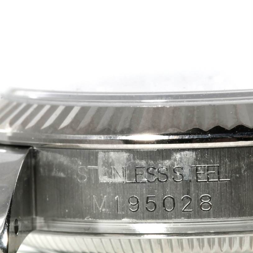 The image shows a close-up side view of the Rolex Mid-Size 178274 Women's Stainless Steel Silver Dial 178274 Women's Stainless Steel Silver Dial watch, focusing on the stainless steel case with engravings.
