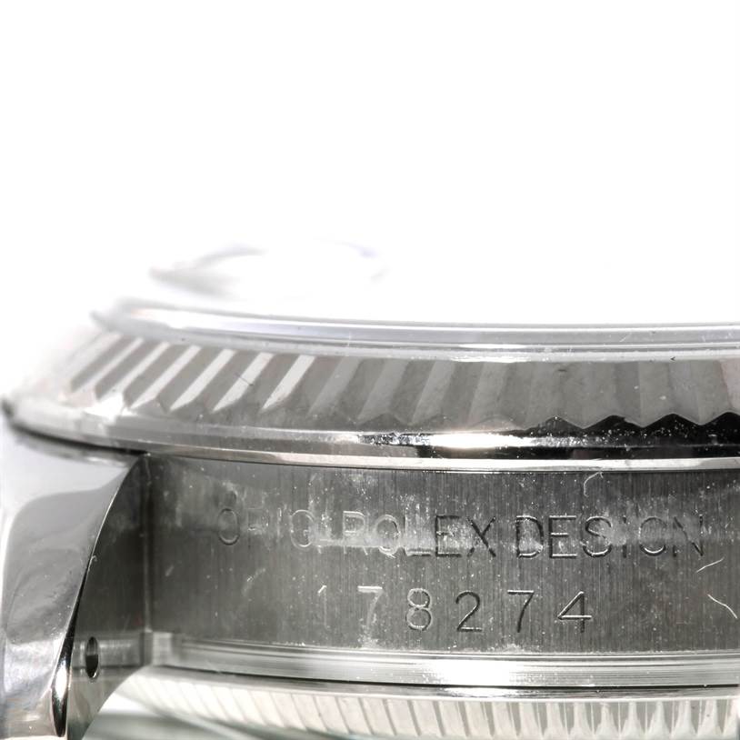 This close-up image of the Rolex Mid-Size 178274 Women's Stainless Steel Silver Dial 178274 Women's Stainless Steel Silver Dial watch shows the side of the case with engraved details.