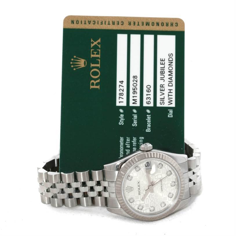 The image shows a Mid-Size Rolex watch with a silver Jubilee dial and diamond markers, with its certificate card behind it.