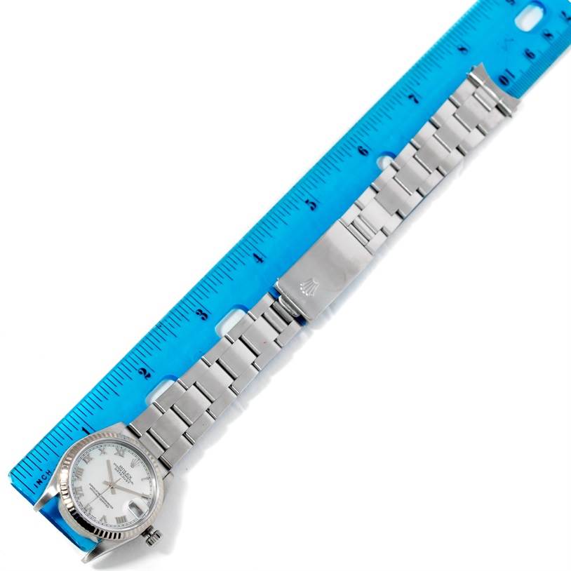 The image shows a top-down view of a Rolex Mid-Size 78274 Women's Stainless Steel Mother of Pearl Dial 78274 Women's Stainless Steel Mother of Pearl Dial watch with a metal bracelet laid beside a ruler.