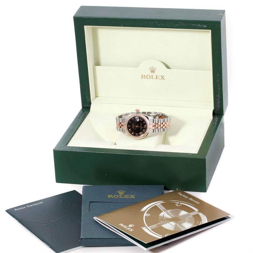 The Rolex Mid-Size 178271 Women's Steel and Gold (two tone) Black Dial 178271 Women's Steel and Gold (two tone) Black Dial watch is shown from the front in an open box, with its manuals and booklets displayed in front.
