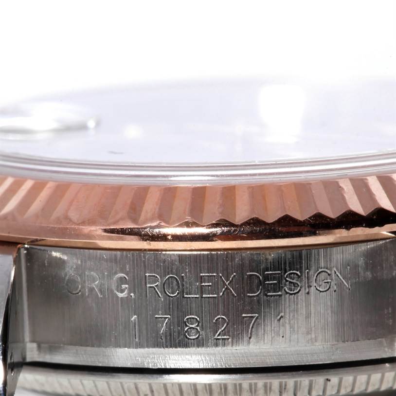 The image shows the side view of a Rolex Mid-Size 178271 Women's Steel and Gold (two tone) Black Dial 178271 Women's Steel and Gold (two tone) Black Dial model, highlighting its fluted bezel and engraved case.