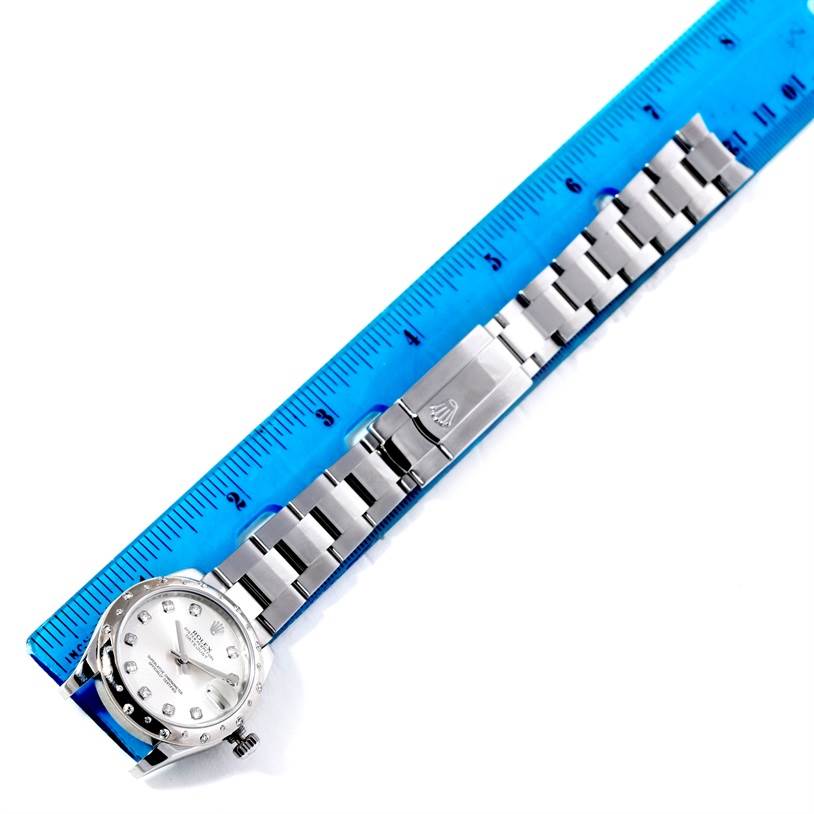 The image shows a horizontal view of a Rolex Mid-Size 178344 Women's Stainless Steel Silver Dial 178344 Women's Stainless Steel Silver Dial model watch and its metal bracelet with a ruler for measurement.