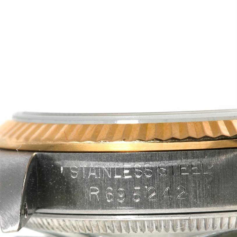 The image shows a close-up side view of the bezel, crystal, and serial number engraving on a mid-size Rolex watch.