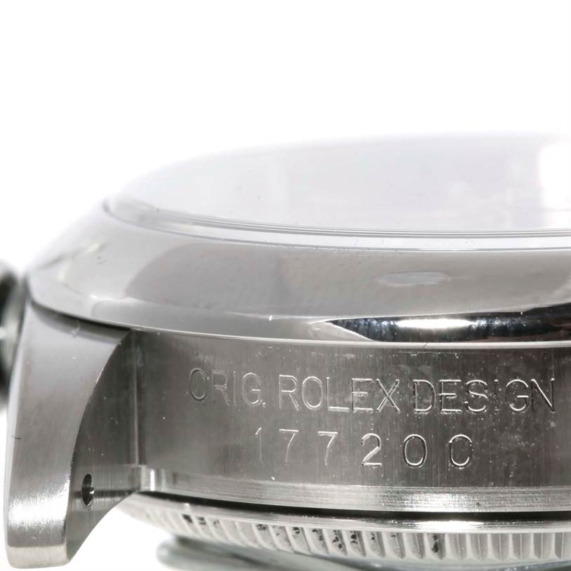 The image shows a close-up side view of a Mid-Size Rolex watch, focusing on the case and bezel with engravings visible.