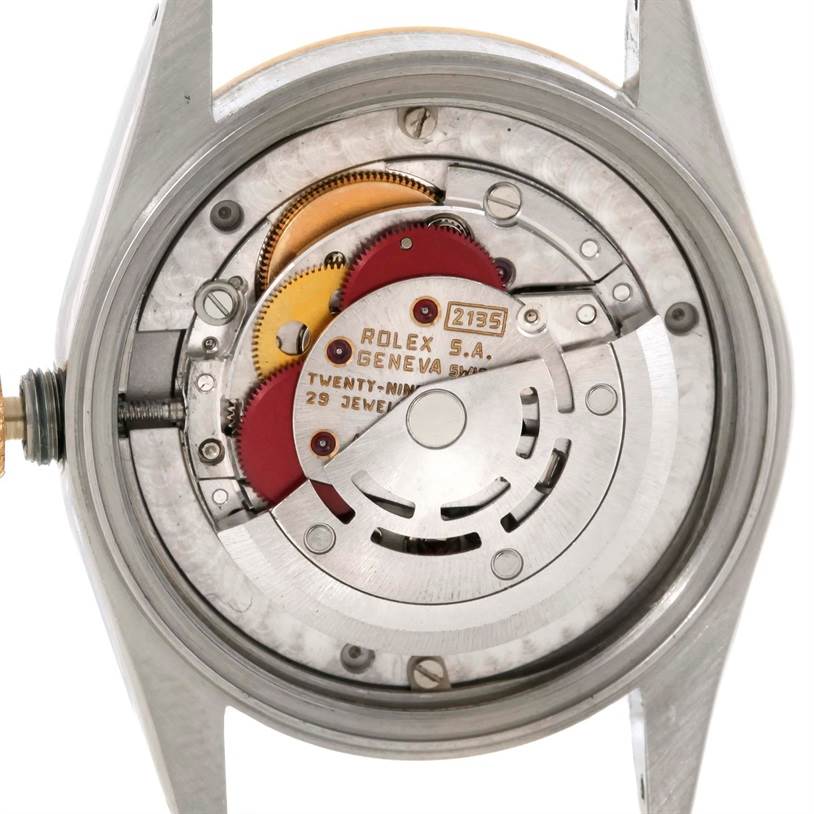 The image shows the inner mechanism and movement parts of a Mid-Size Rolex watch from a back angle with the case removed.