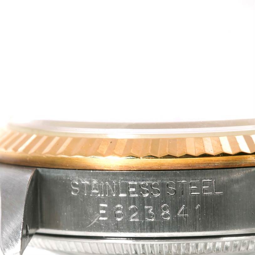 The image shows a close-up of the bezel and serial number on the side of a Mid-Size Rolex watch, made of stainless steel and gold.