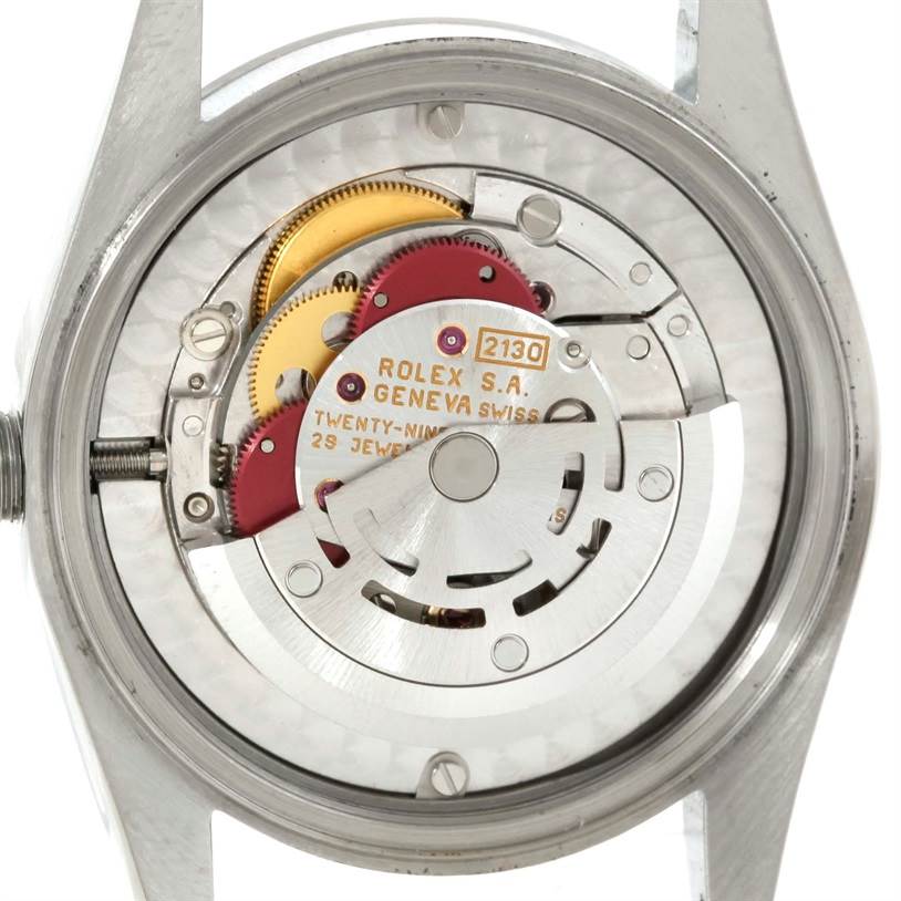 The image shows the internal mechanics of a Mid-Size Rolex watch from a rear angle, showcasing the movement and rotor.
