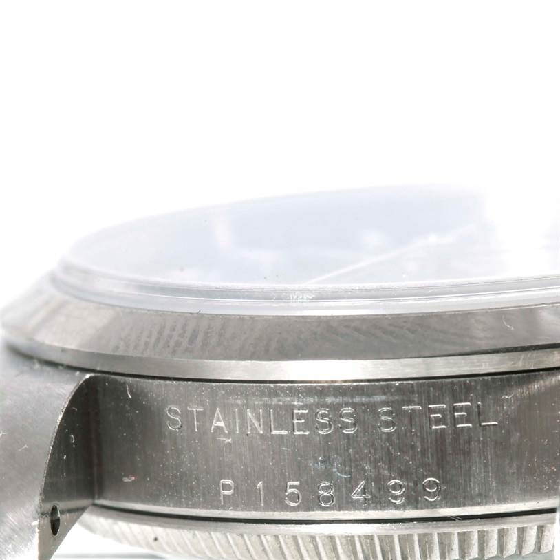 The image shows a close-up of the side of a mid-size Rolex watch, highlighting the stainless steel case with its model number engraved.