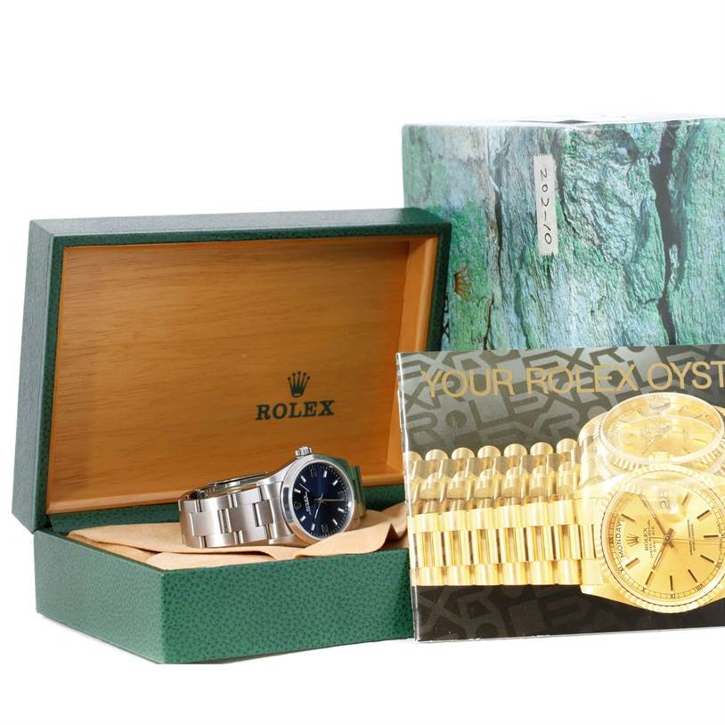 The image shows a Mid-Size Rolex watch in its open green and wooden box, along with accompanying packaging and an informational booklet.