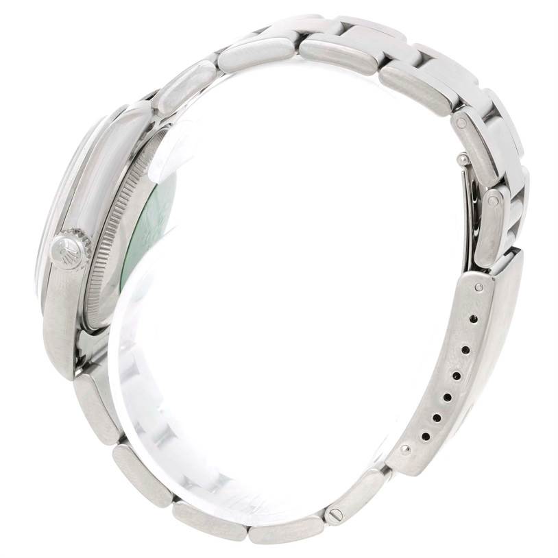 This image shows a side view of a Rolex Mid-Size 77080 Women's Stainless Steel Blue Dial 77080 Women's Stainless Steel Blue Dial watch, showcasing its crown, case, and metal bracelet with adjustment holes.