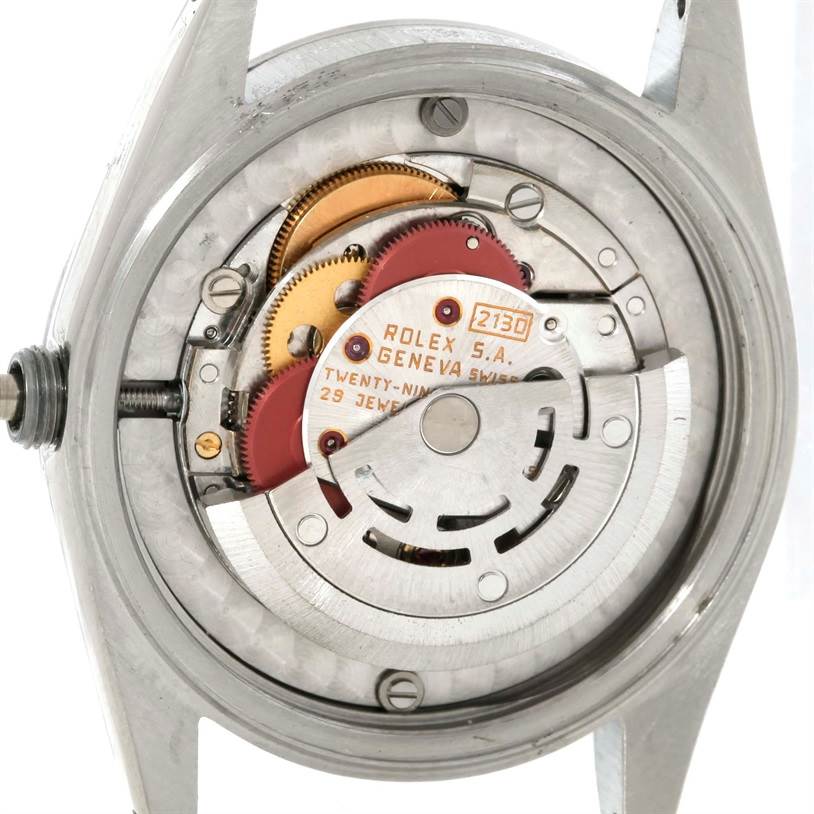 The image shows the movement mechanism of a Mid-Size Rolex watch from a rear angle with the case back removed.