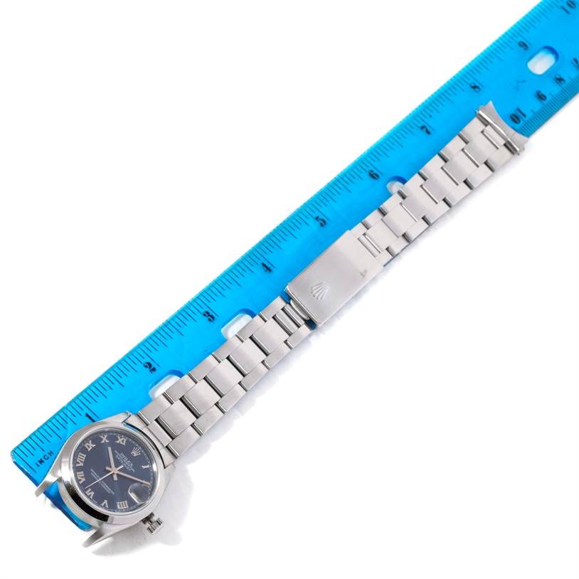 The image shows a Rolex Mid-Size 68240 Women's Stainless Steel Blue Dial 68240 Women's Stainless Steel Blue Dial model watch lying flat, highlighting the watch face, bracelet, and clasp with a ruler beside it.