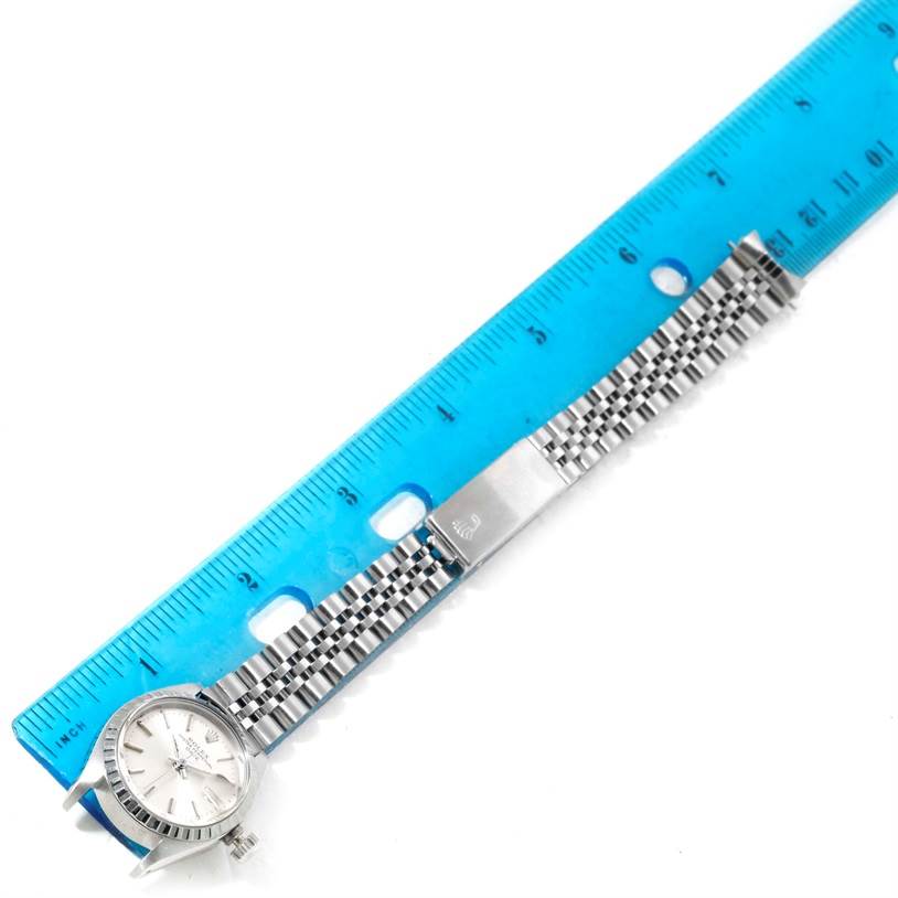 This image shows a Rolex Date 6924 Women's Stainless Steel Silver Dial 6924 Women's Stainless Steel Silver Dial model watch lying flat, with a blue ruler displaying its length.