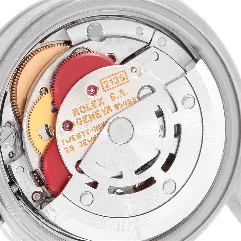 The image shows the internal mechanism of the Rolex Date 69240 Women's Stainless Steel Silver Dial 69240 Women's Stainless Steel Silver Dial watch model from a close-up angle, revealing its gears and inscriptions.