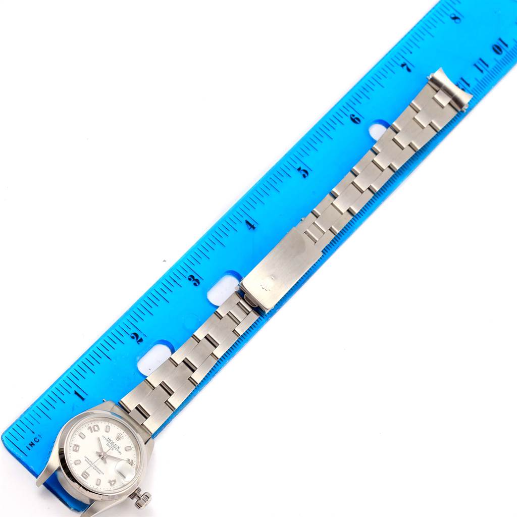 The image shows a Rolex Date 69160 Women's Stainless Steel White Dial 69160 Women's Stainless Steel White Dial watch laid flat with the bracelet extended against a blue ruler.