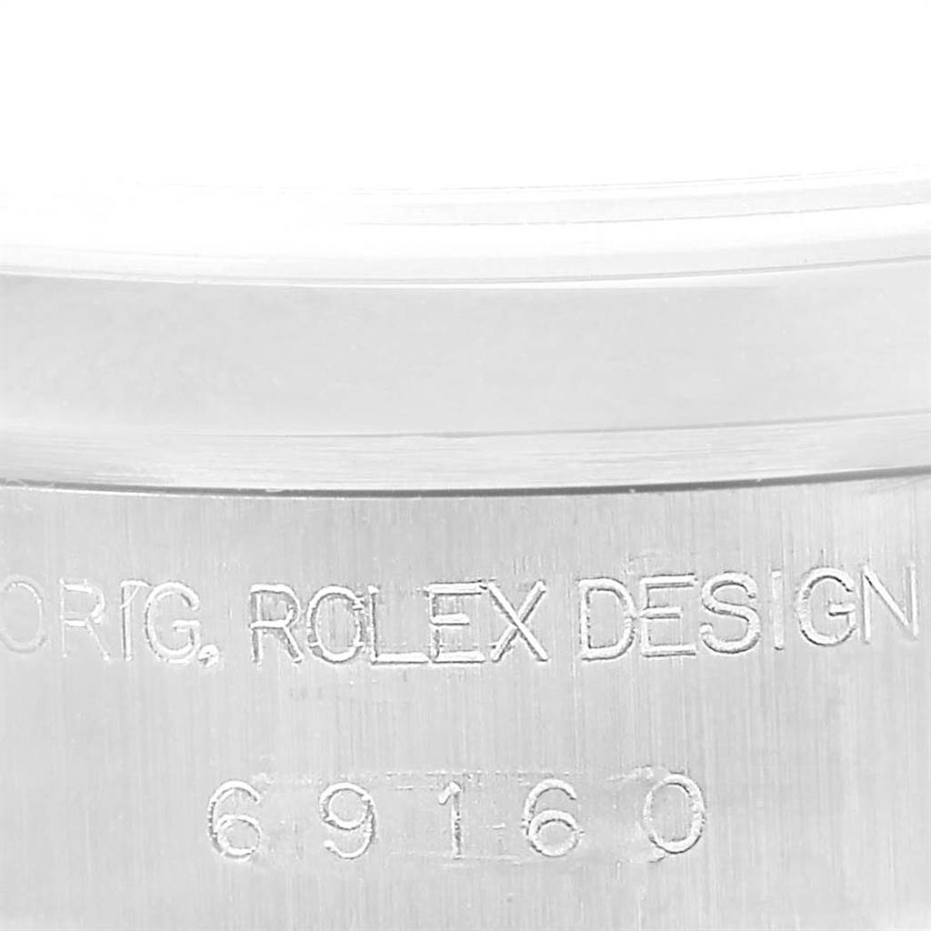 This is a close-up view of the side of a Rolex Date 69160 Women's Stainless Steel White Dial 69160 Women's Stainless Steel White Dial model showing the engraving on the case.