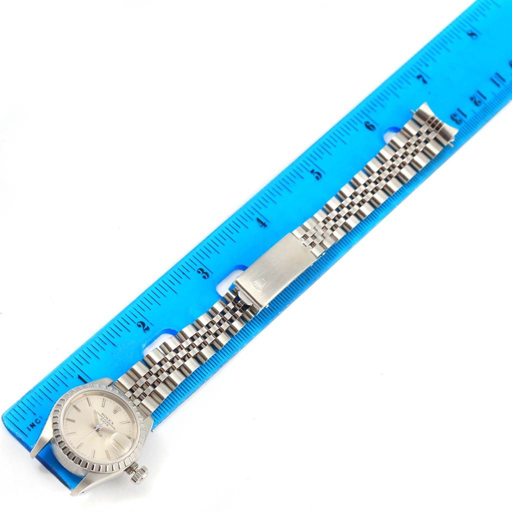 The image shows a Rolex Date 69240 Women's Stainless Steel Silver Dial 69240 Women's Stainless Steel Silver Dial model watch and its metal strap laid next to a ruler for measurement.