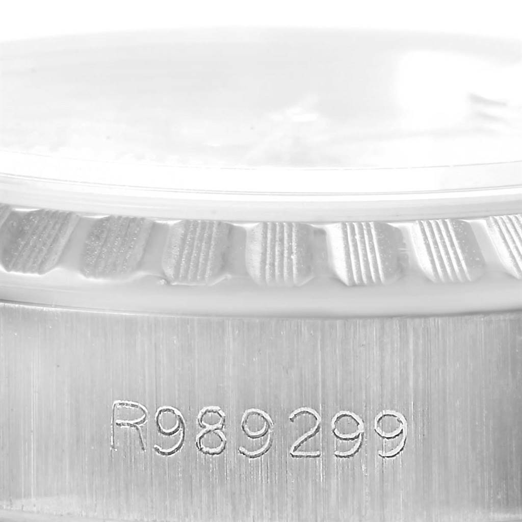 This is a close-up image of the case side and bezel of a Rolex Date 69240 Women's Stainless Steel Silver Dial 69240 Women's Stainless Steel Silver Dial model watch, showing the serial number "R989299."