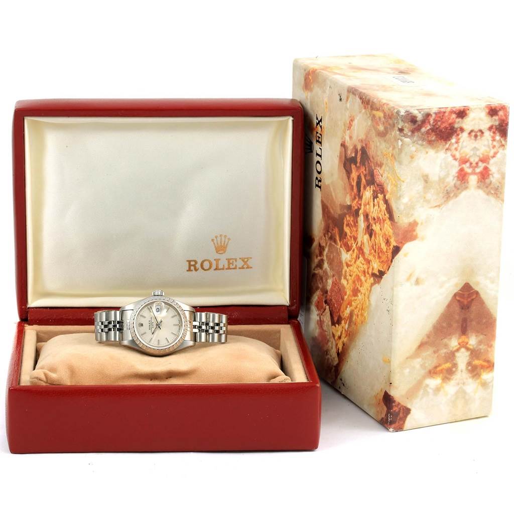 The image shows a Rolex Date 69240 Women's Stainless Steel Silver Dial 69240 Women's Stainless Steel Silver Dial model watch placed inside its open red box, with the box lid upright and a decorative outer box nearby.