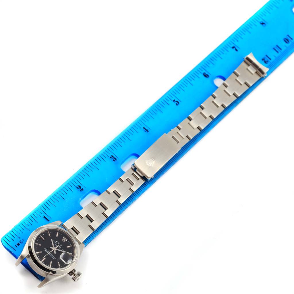 This image shows the Rolex Date 79160 Women's Stainless Steel Black Dial 79160 Women's Stainless Steel Black Dial watch placed alongside a ruler, showcasing the watch face, bracelet, and clasp.