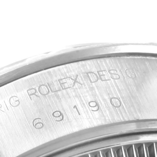 The image shows a close-up of the engraved case side of a Rolex Date 69190 Women's Stainless Steel Blue Dial 69190 Women's Stainless Steel Blue Dial model watch.