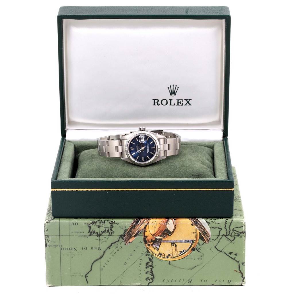 This image shows a Rolex Date 69190 Women's Stainless Steel Blue Dial 69190 Women's Stainless Steel Blue Dial model watch in a green Rolex box with a map-themed outer box.