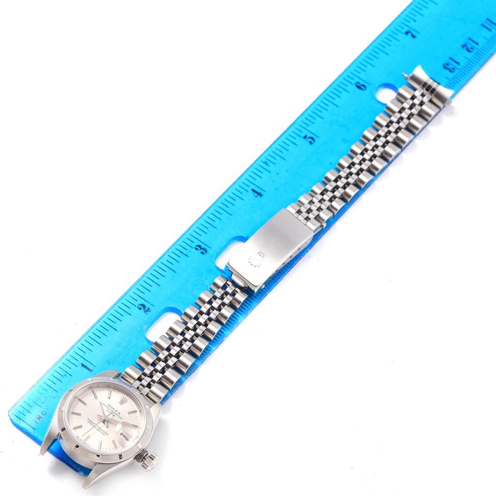 This image shows a Rolex Date 79190 Women's Stainless Steel Silver Dial 79190 Women's Stainless Steel Silver Dial model watch laid flat next to a ruler, highlighting the face and Jubilee bracelet.