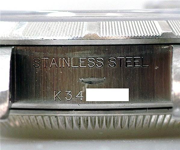 The image shows a close-up view of the side of a Rolex Date 79190 Women's Stainless Steel Black Dial 79190 Women's Stainless Steel Black Dial model watch, highlighting the "STAINLESS STEEL" engraving and partial serial number.