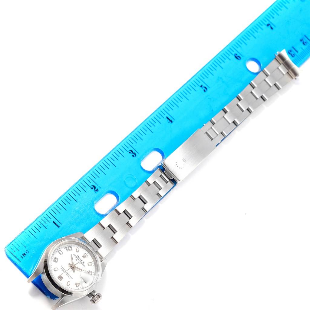 The image shows the Rolex Date 79160 Women's Stainless Steel White Dial 79160 Women's Stainless Steel White Dial watch lying flat next to a blue ruler, displaying the case, dial, and bracelet.
