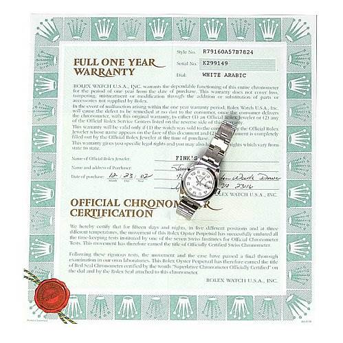 The image shows a Rolex Date 79160 Women's Stainless Steel White Dial 79160 Women's Stainless Steel White Dial model watch placed atop its warranty and certification documents, displaying its face and bracelet.