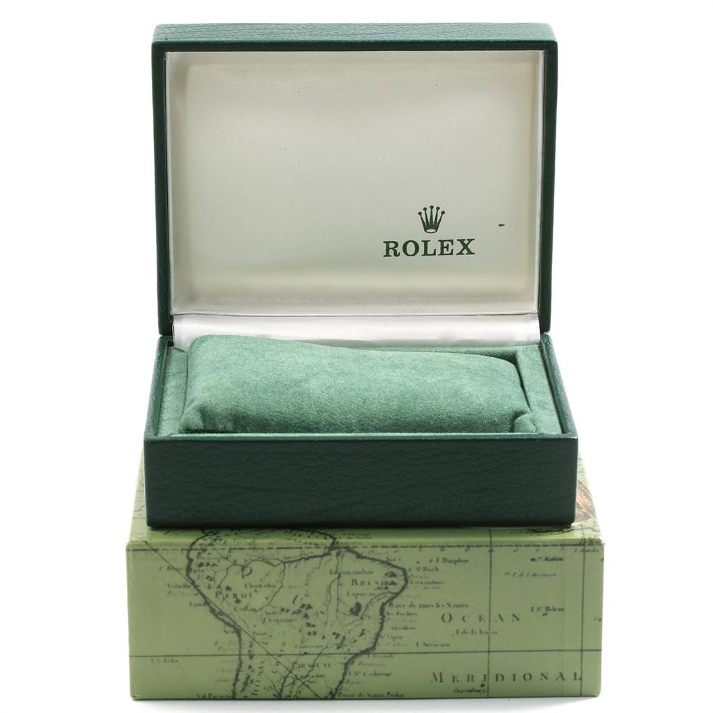 The image shows a Rolex Date 79160 Women
s Stainless Steel Blue Dial 79160 Women
s Stainless Steel Blue Dial watch box, open, with a green cushion inside and a map-themed outer box below.