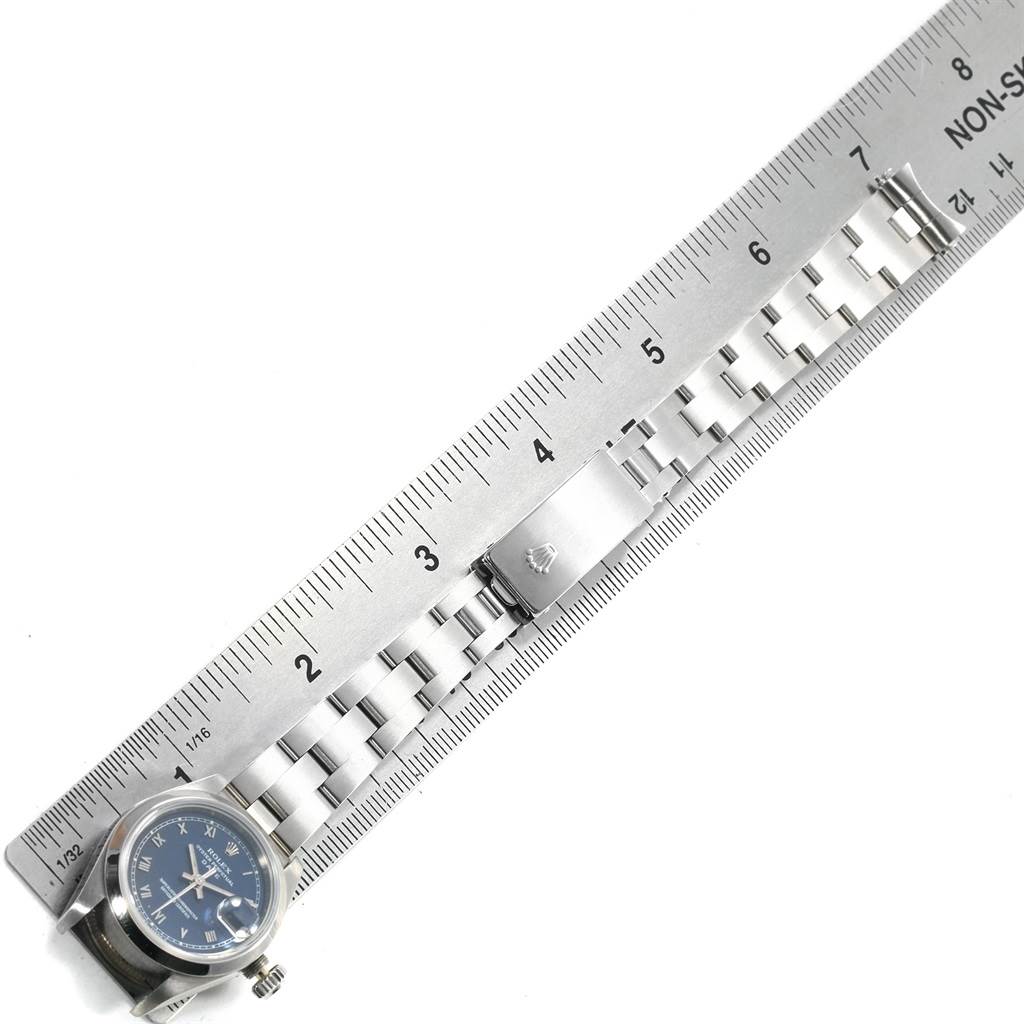This Rolex Date 69160 Women's Stainless Steel Blue Dial 69160 Women's Stainless Steel Blue Dial watch is shown from a top-down angle, displaying its bracelet alongside a ruler.