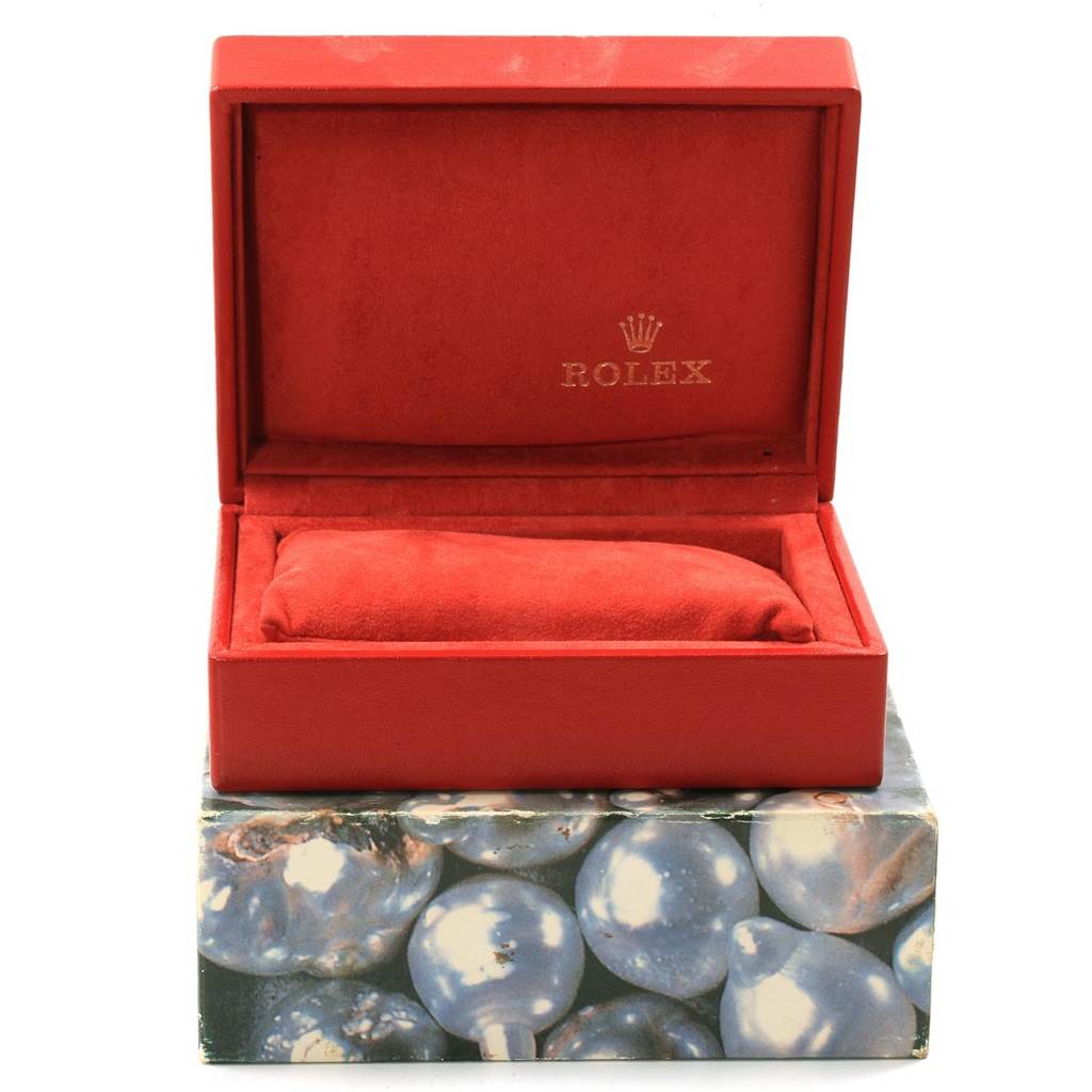 The image shows an open red Rolex watch box, likely for a Date model, with a red cushion inside and the Rolex logo visible.