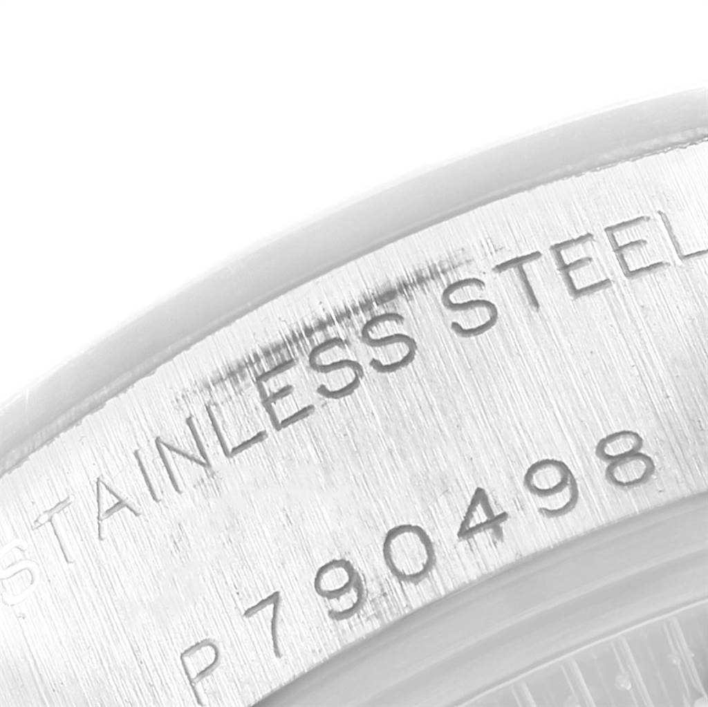 This close-up image shows the engraved serial number and "STAINLESS STEEL" text on the case of a Rolex Date 79160 Women
s Stainless Steel Black Dial 79160 Women
s Stainless Steel Black Dial model watch.