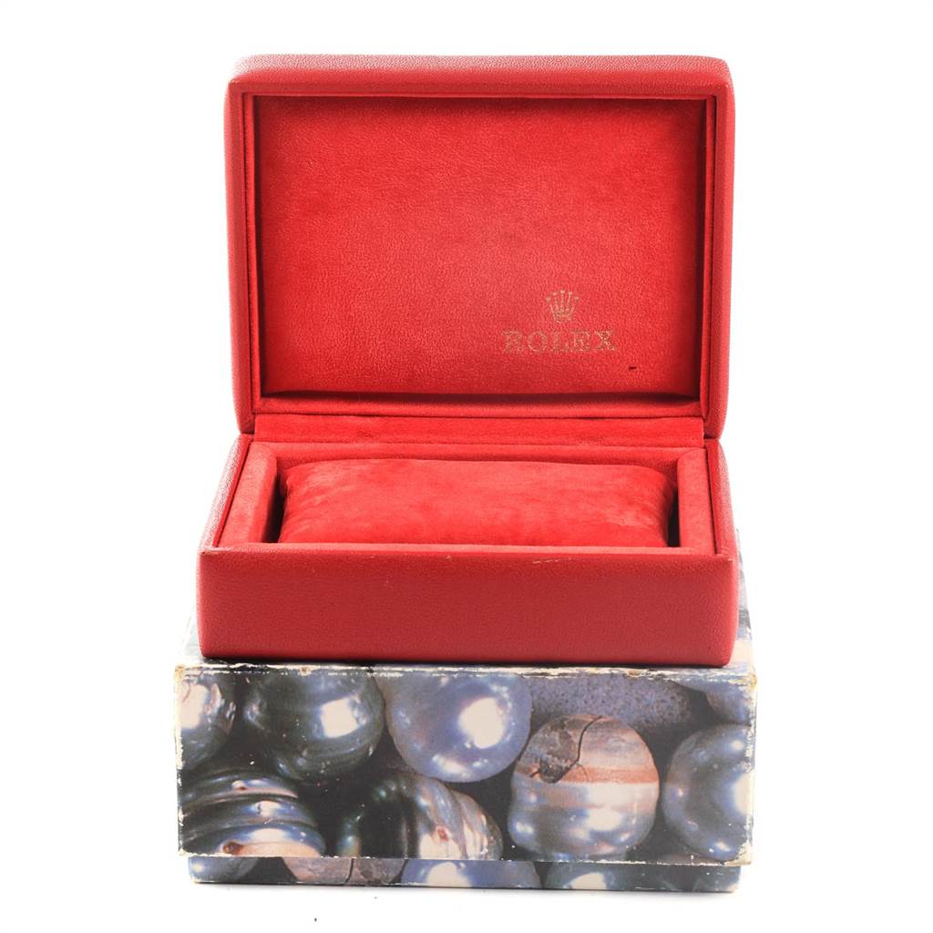 This image shows an open red Rolex box for the Date model, placed on a decorative outer box.