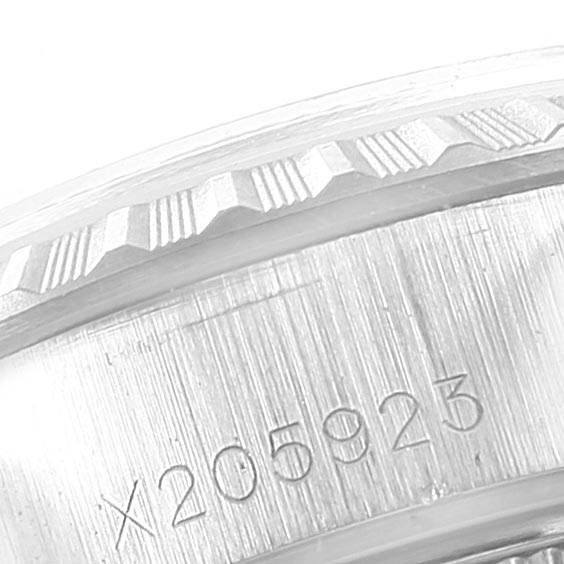 The image shows a close-up view of the Rolex Date 69240 Women's Stainless Steel White Dial 69240 Women's Stainless Steel White Dial model's engraved serial number and part of its fluted bezel.