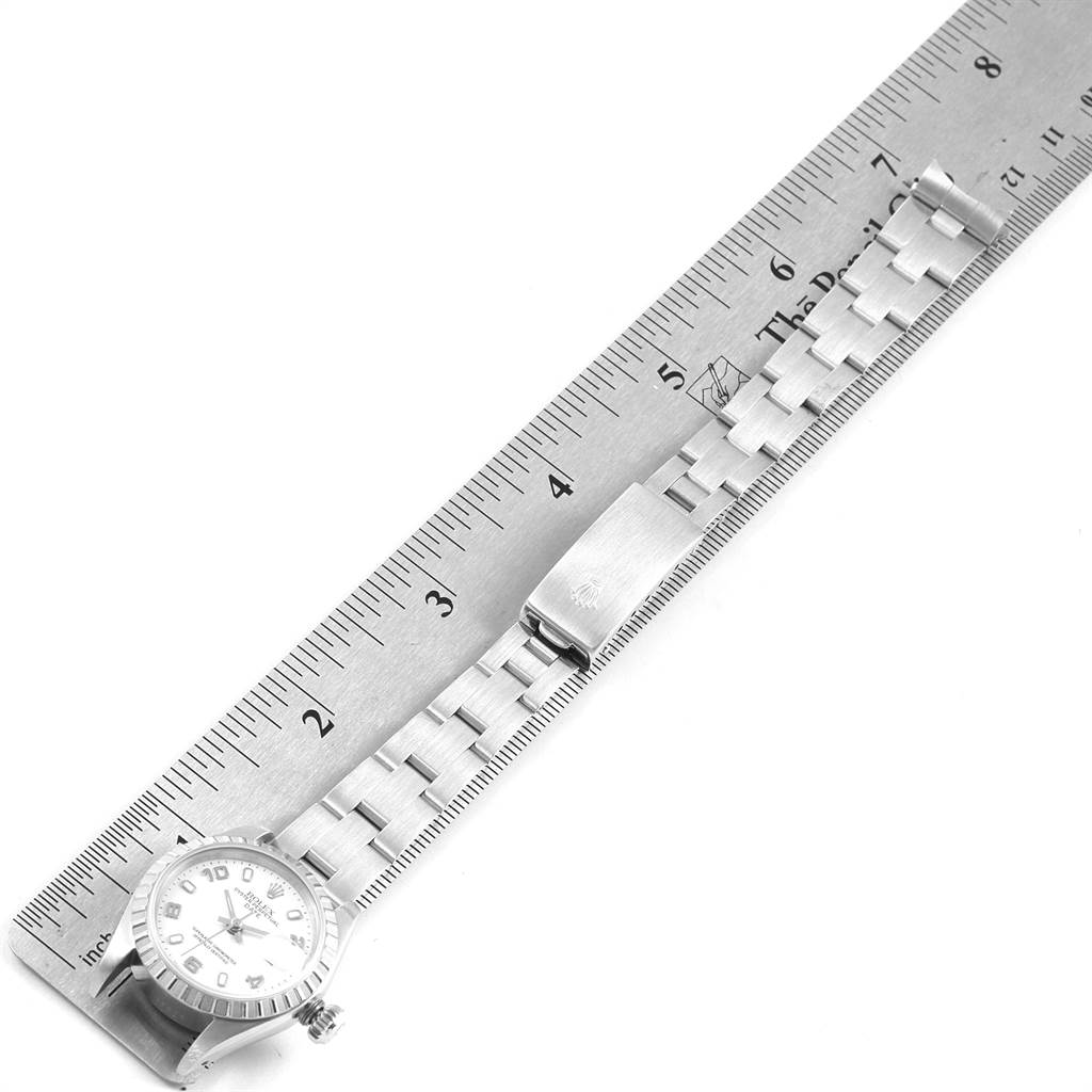 The image shows a Rolex Date 69240 Women's Stainless Steel White Dial 69240 Women's Stainless Steel White Dial model watch with a metal band next to a ruler, viewed from a top angle.