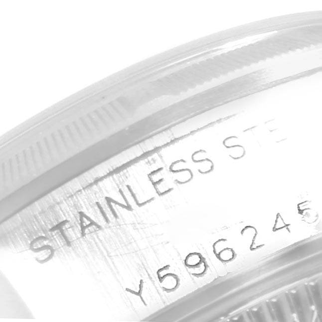 The image shows a close-up of the side of a Rolex Date 79190 Women's Stainless Steel White Dial 79190 Women's Stainless Steel White Dial watch, highlighting the engraved serial number and "STAINLESS STEEL."