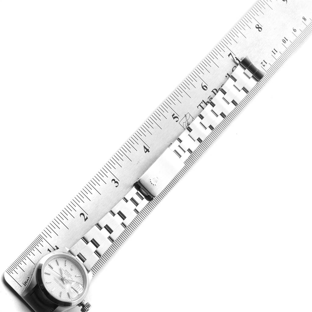 The image shows a Rolex Date 69160 Women
s Stainless Steel Silver Dial 69160 Women
s Stainless Steel Silver Dial model watch laid flat alongside a ruler, displaying the watch face, bracelet, and clasp.